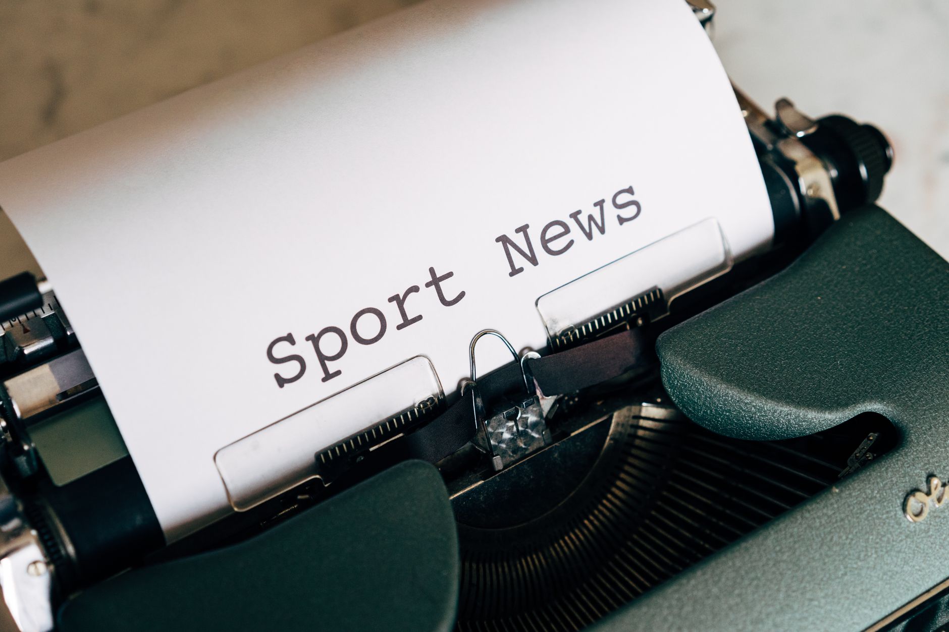 Close-up of a vintage typewriter with 'Sport News' typed on paper, evoking retro charm. — Gama Casino: Ein Blick auf die aktu