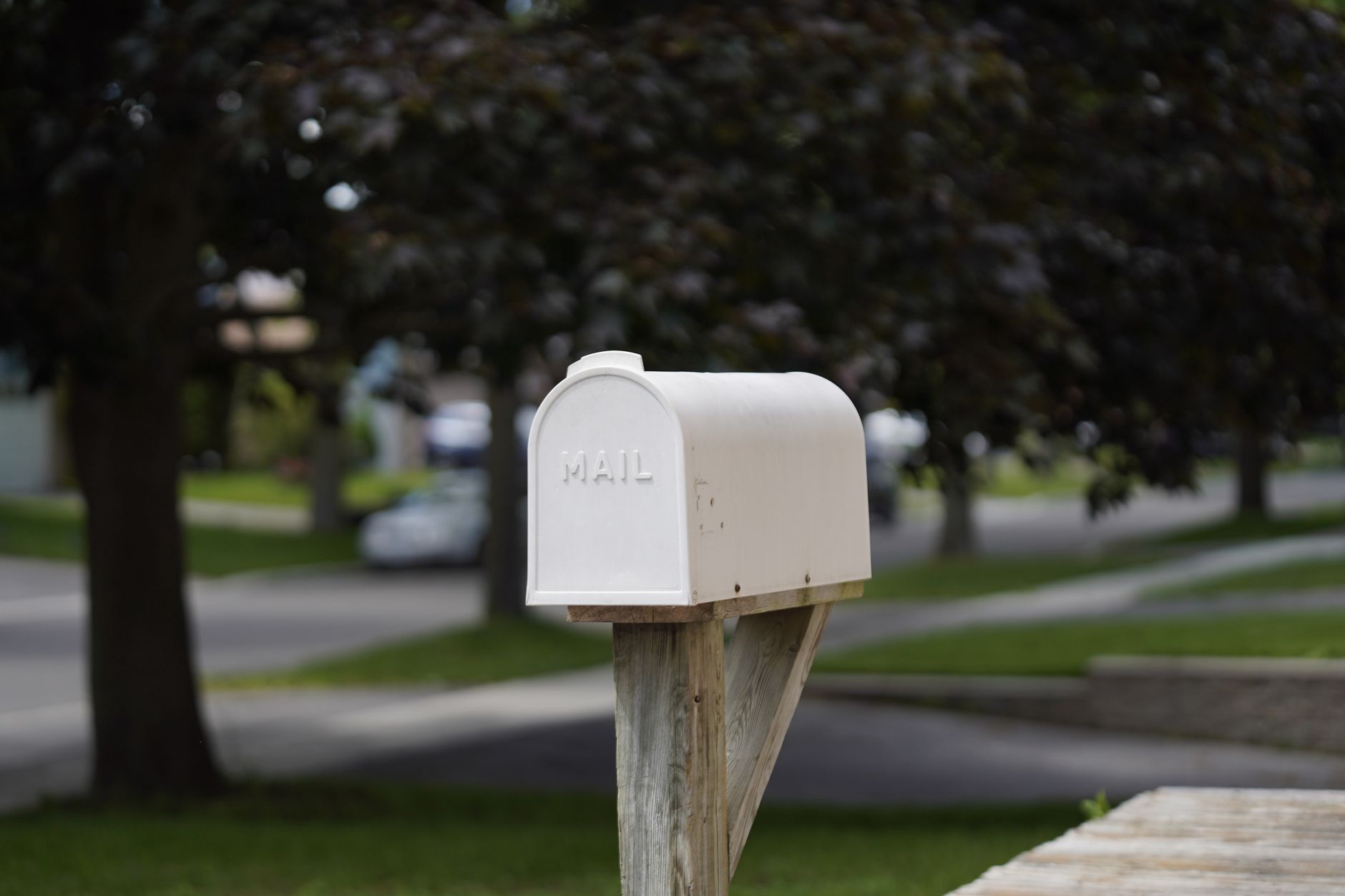Simple white mailbox near the street in a suburban neighborhood with a blurred background. — Prachtige_kansen_en_luckygem_voo