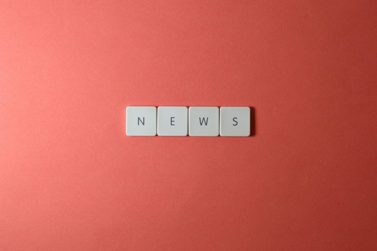 Close-up of keyboard keys spelling 'NEWS' on a red background, minimalist style. — Wie sinnvoll sind VIP-Programme im LuckyHi