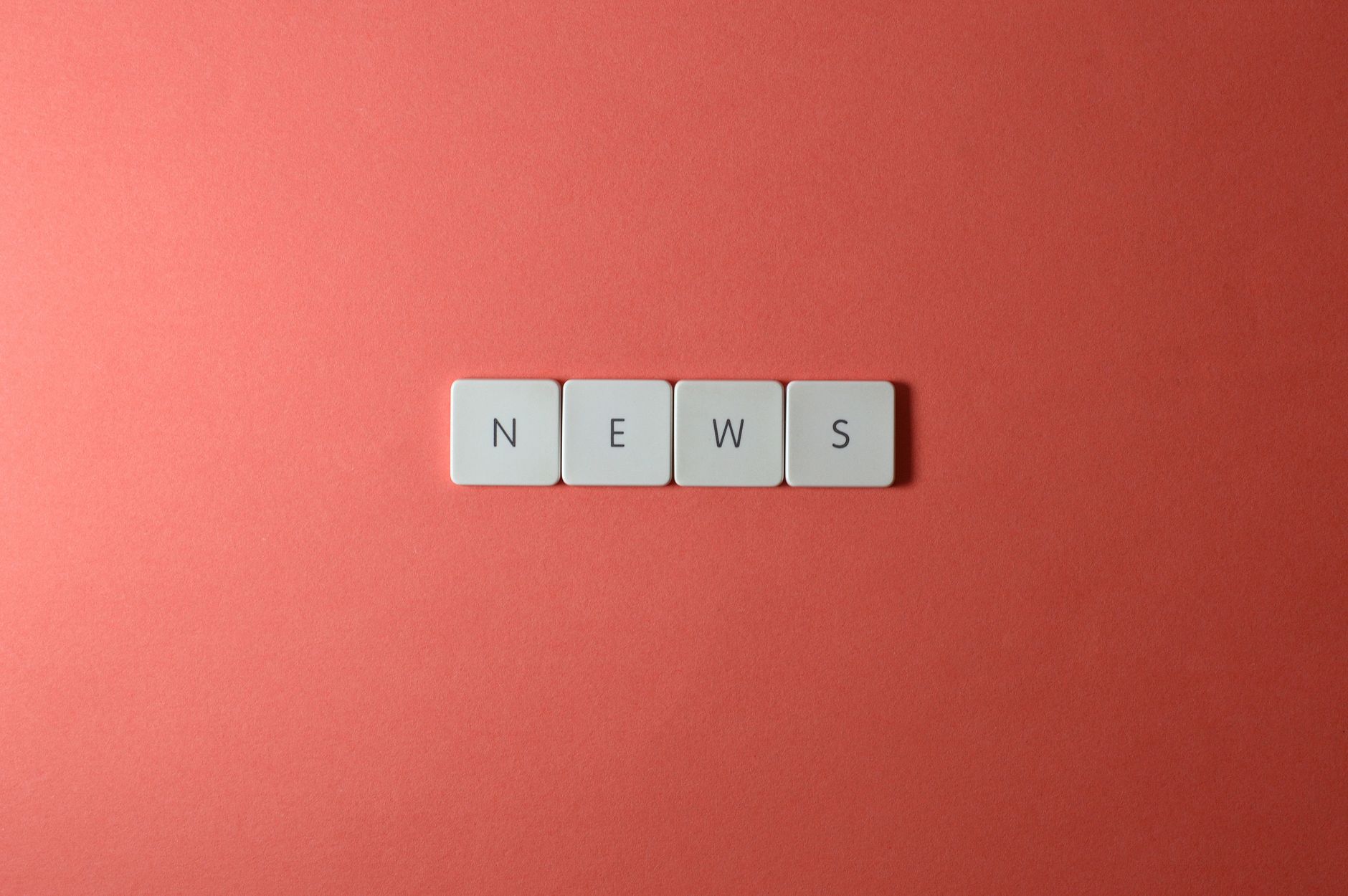 Close-up of keyboard keys spelling 'NEWS' on a red background, minimalist style. — Wie sinnvoll sind VIP-Programme im LuckyHi